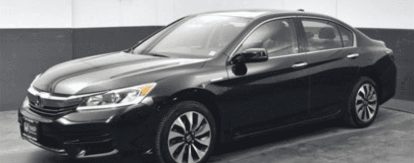 Black sedan car in showroom setting.